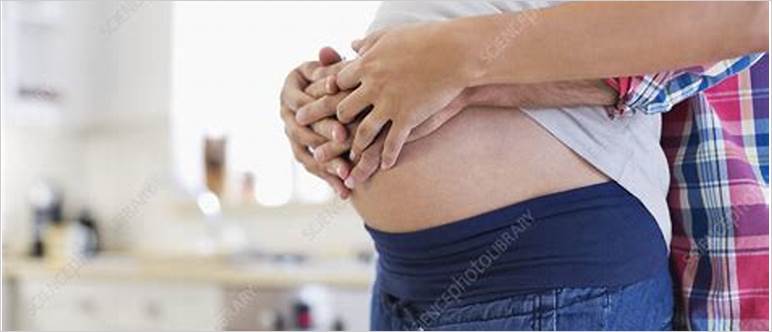 Man holding pregnant belly